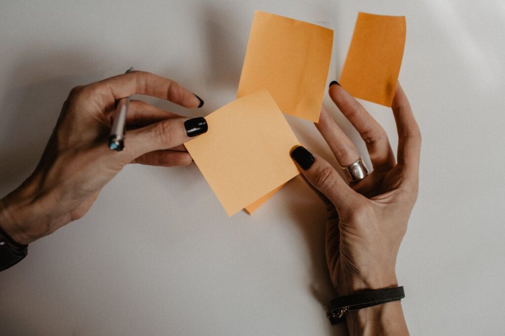 lady holding orange postits in her hands